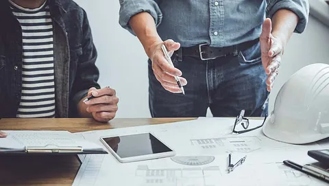 To personer ser på plantegninger